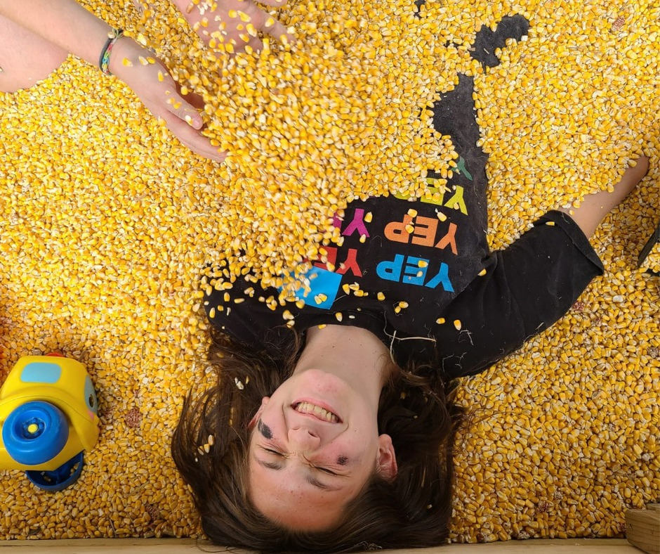 Child playing in the corn pit at Govin's Farm