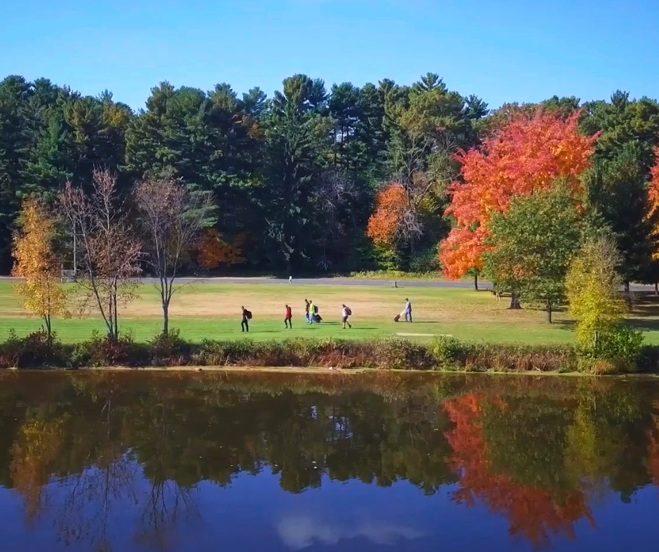 People walking beside lake Menomin in Wakanda park